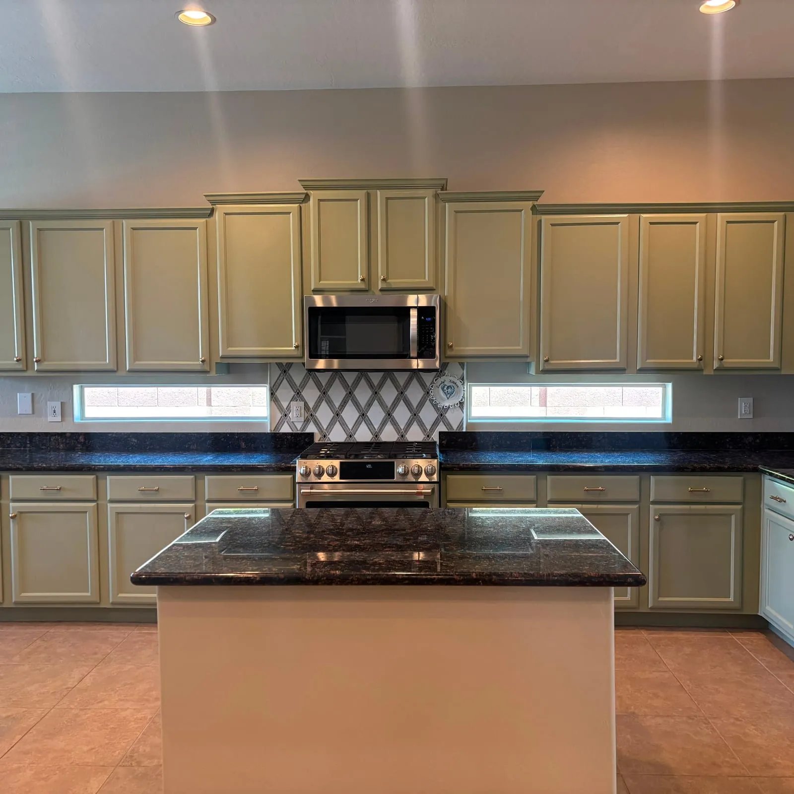 A kitchen with cabinets refinished in sage green by Paradise Painting